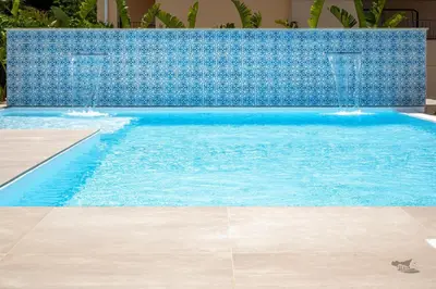 a swimming pool with a blue tile wall at Villa DellAcqua in Alcamo Marina
