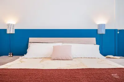 a bedroom with a large bed with a blue wall at Villa DellAcqua in Alcamo Marina