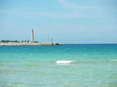 a body of water with a lighthouse in the background at VILLA TREROSE by Trerose Properties - Villa centrale con wi-fi e posto auto privato gratuiti in San Vito lo Capo