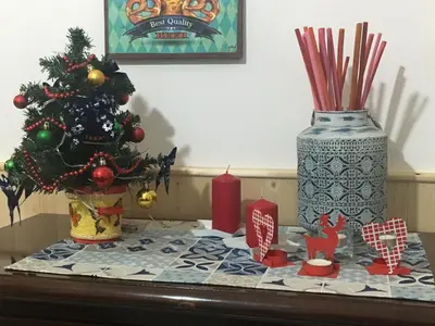 a table with a christmas tree and a vase at La Casetta di Andrea & Vale in Termini Imerese