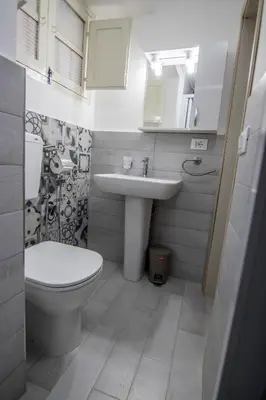 a bathroom with a toilet and a sink at Vivere la Ciambra in Monreale