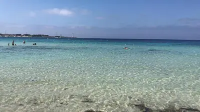 a group of people in the water at the beach at La maison sul mare in San Vito lo Capo