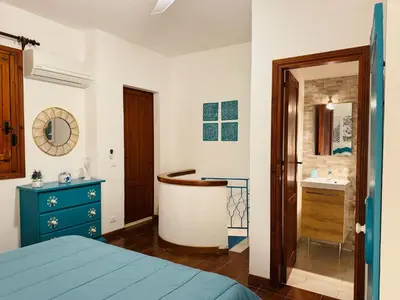 a bedroom with a blue bed and a sink at La maison sul mare in San Vito lo Capo
