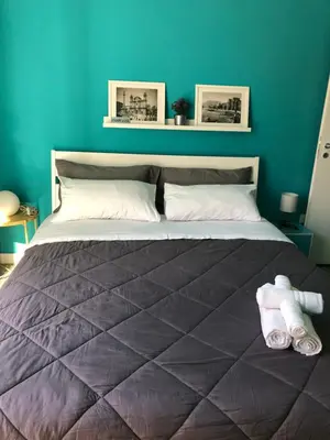 a bedroom with a large bed with a blue wall at Jennys place in Palermo