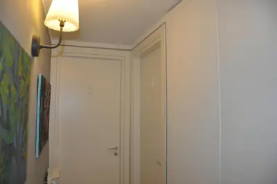 a hallway with a white door and a lamp at Jennys place in Palermo