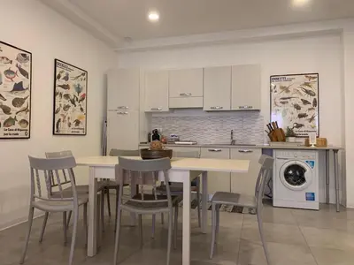 a kitchen with a table and chairs and a dishwasher at Casa4Casa in Palermo