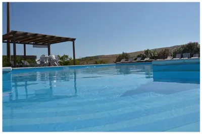 a large swimming pool with blue water at Agriturismo Sant'Agata in Piana degli Albanesi