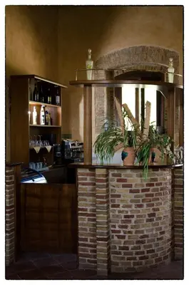 a bar in a restaurant with a brick wall at Agriturismo Sant'Agata in Piana degli Albanesi
