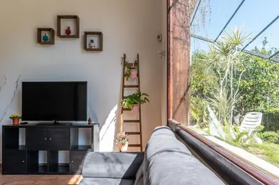 a living room with a tv and a large window at Bouganville Home Mondello in Mondello