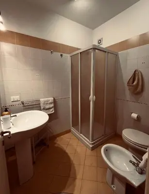 a bathroom with a shower and two sinks and a toilet at Sicilia Vacation in San Vito lo Capo