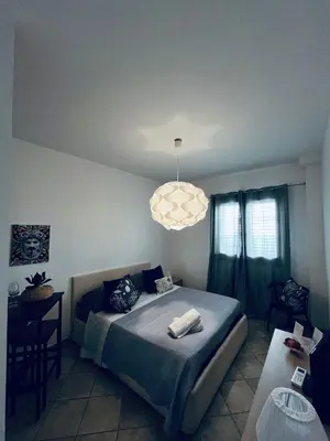 a bedroom with a large bed and a chandelier at Sicilia Vacation in San Vito lo Capo