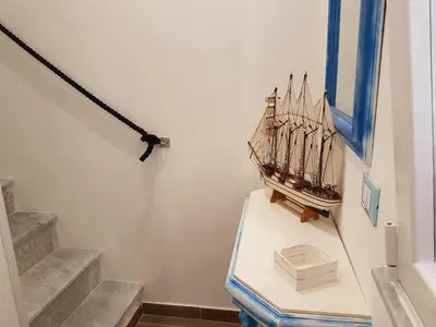 a room with stairs and a boat on the wall at La Rosa dei Venti in Isola delle Femmine
