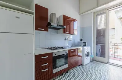 a kitchen with a stove top oven next to a refrigerator at GuestHost - Palermo Central Apartment in Palermo