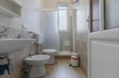 a white bathroom with a sink and a toilet at GuestHost - Palermo Central Apartment in Palermo