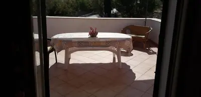 a table and a chair on a patio at Villa Plaia in Castellammare del Golfo