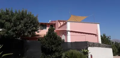 a pink house with a fence in front of it at Villa Plaia in Castellammare del Golfo