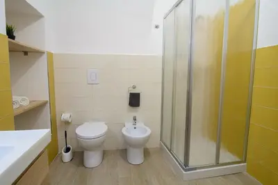 a bathroom with a toilet and a glass shower at Ficodì apartments in Alcamo