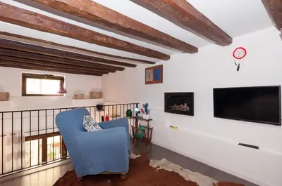 a living room with a blue chair and a flat screen tv at Casetta di Pietre Chico in Palermo