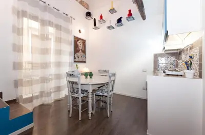 a kitchen and dining room with a table and chairs at Casetta di Pietre Chico in Palermo