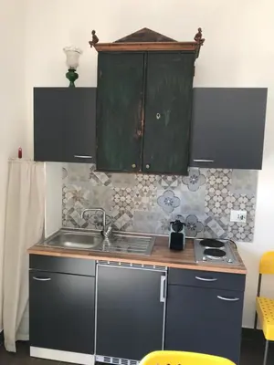 a kitchen with a sink and a green cabinet at Casetta dei Legni in Palermo