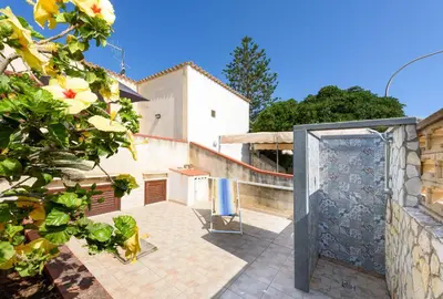 a view of a patio with a gate and a house at Casa Vacanza Azzurra 3 in San Vito lo Capo