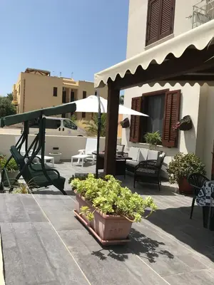 a patio with potted plants and a swing at Casa Rosita in San Vito lo Capo