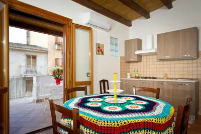 a kitchen with a table with a colorful table cloth on it at Il Sole di Sicilia in Castellammare del Golfo