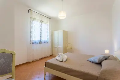 a bedroom with a bed with a stuffed animal on it at Appartamenti Karma vacanze in Castelluzzo