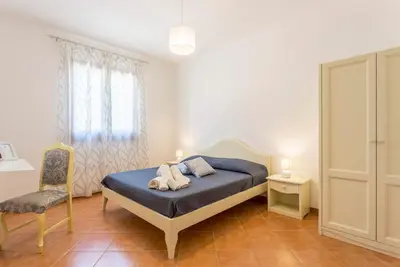 a bedroom with a bed and a chair at Appartamenti Karma vacanze in Castelluzzo