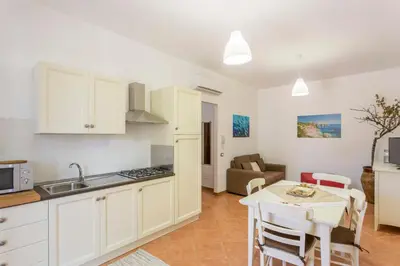 a kitchen and living room with a table and a kitchen and a dining room at Appartamenti Karma vacanze in Castelluzzo