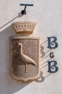 a clock with a bird on the side of a building at Casa Manzella in Terrasini