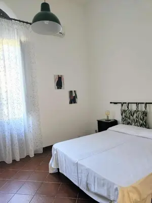 a bedroom with a white bed and a window at Marina in Castellammare del Golfo