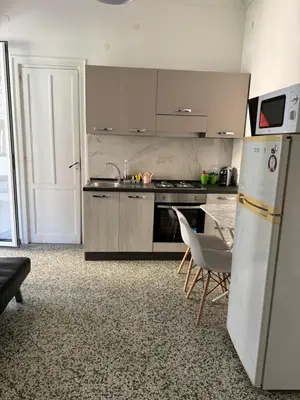 a kitchen with a refrigerator and a table and chairs at Holiday mondello martina in Mondello