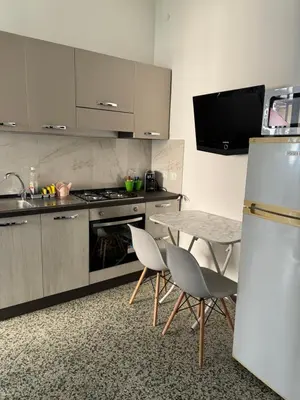 a kitchen with a table and chairs and a refrigerator at Holiday mondello martina in Mondello