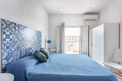 a bedroom with a blue bed with a blue patterned headboard at Frank's house - appartamento con terrazzo in centro in Palermo