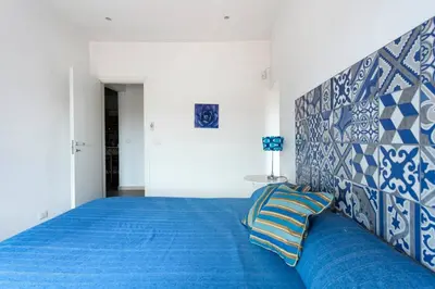 a bedroom with a blue bed with a blue and white headboard at Frank's house - appartamento con terrazzo in centro in Palermo