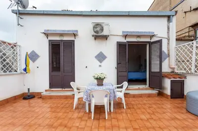 a patio with a table and chairs and a house at Frank's house - appartamento con terrazzo in centro in Palermo