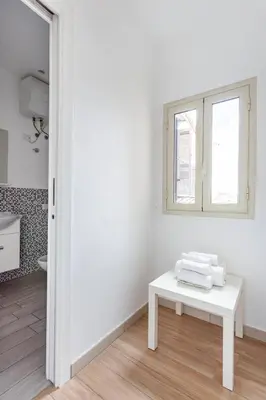 a white room with a table and a window at Frank's house - appartamento con terrazzo in centro in Palermo