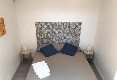 a small bedroom with a bed with blue pillows at Frank's house - appartamento con terrazzo in centro in Palermo