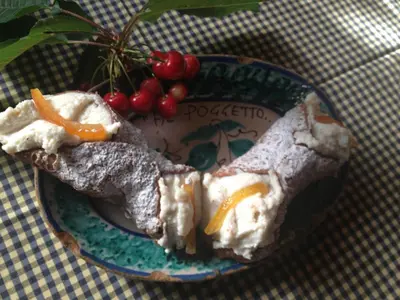 a plate of food on a table next to a plant at Agriturismo Al Poggetto in Piana degli Albanesi