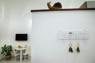 a room with a white wall with a sign that reads love at Via Vittorio Emanuele Apartment in Palermo