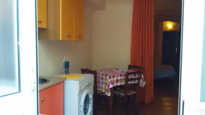 a kitchen with a table and a washing machine at vibavacanze in Palermo