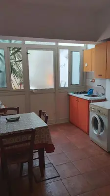 a kitchen with a table and a washing machine at vibavacanze in Palermo