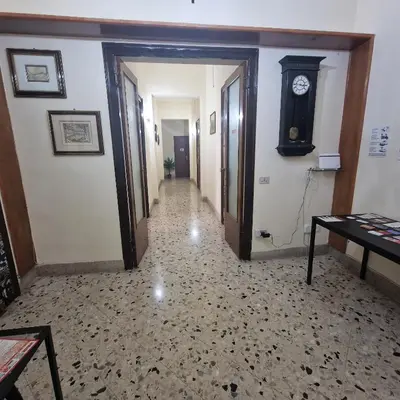 a hallway with a clock on the wall and a hallway with a table at Arco di Trionfo Palermo Bed & Breakfast in Palermo