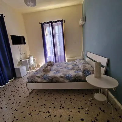 a bedroom with a bed with a teddy bear on it at Arco di Trionfo Palermo Bed & Breakfast in Palermo