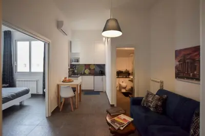 a living room with a blue couch and a kitchen at Teatro Massimo Cool Home in Palermo