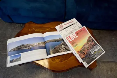 two magazines sitting on top of a wooden table at Teatro Massimo Cool Home in Palermo
