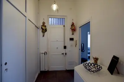 a hallway with a white door and a table at Teatro Massimo Cool Home in Palermo