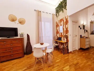 a living room with a table and chairs and a tv at Natoli Apartments in Palermo