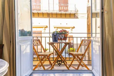 a balcony with a table and chairs on a balcony at Natoli Apartments in Palermo